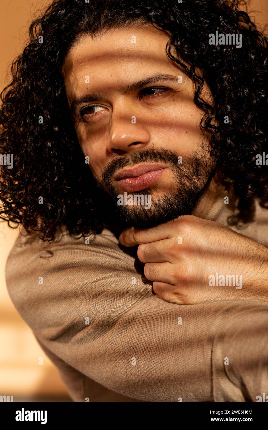 Homme réfléchi avec les cheveux noirs et la barbe appuyée sur la main Banque D'Images