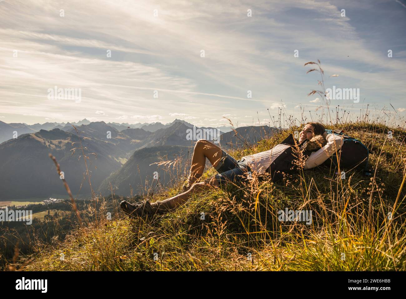 Jeune femme reposant sur le rocher à Tannheimer Tal, Tyrol, Autriche Banque D'Images