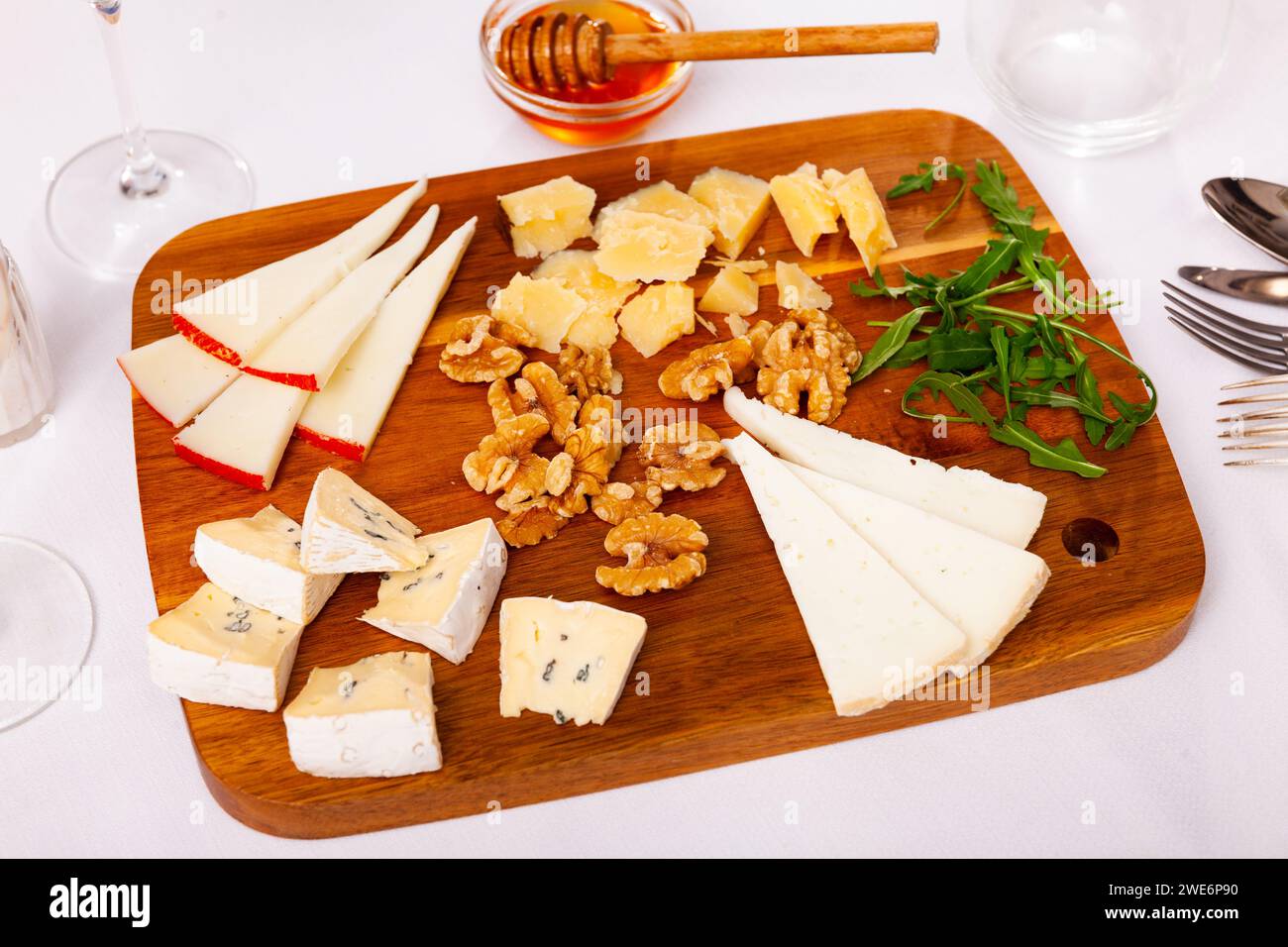 Différents types de fromage servis sur bois avec du miel, des tranches de noix Banque D'Images