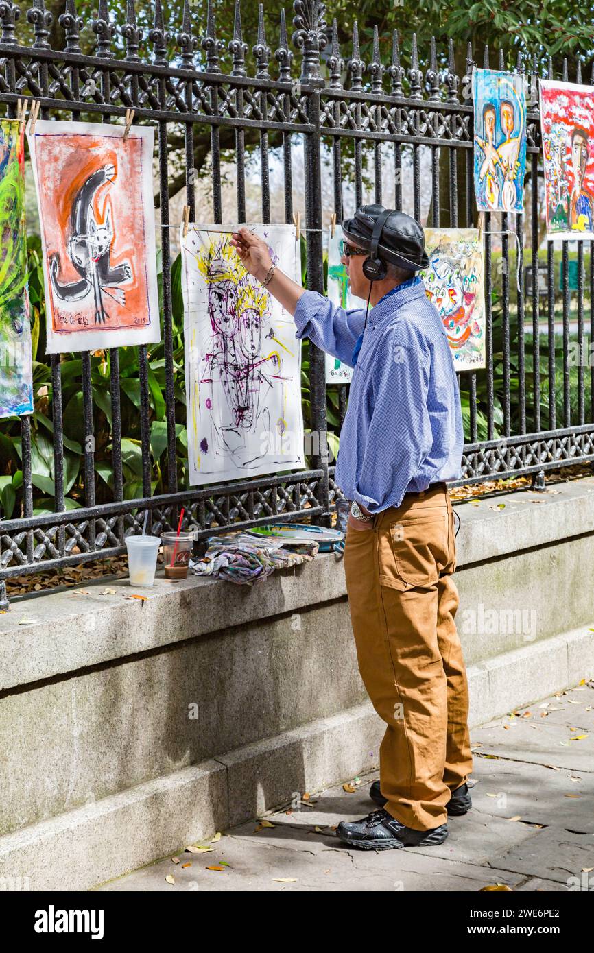 Artiste peignant une toile accrochée à une clôture en fer forgé autour de Jaskson Square dans le quartier français de la Nouvelle-Orléans, Louisiane Banque D'Images