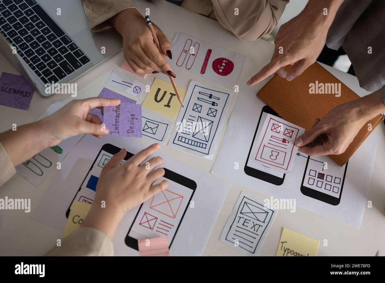 Image vue de dessus d'une équipe de graphistes UX UI professionnelle et créative votant un prototype parfait pour leur nouveau produit, discutant et planifiant WO Banque D'Images