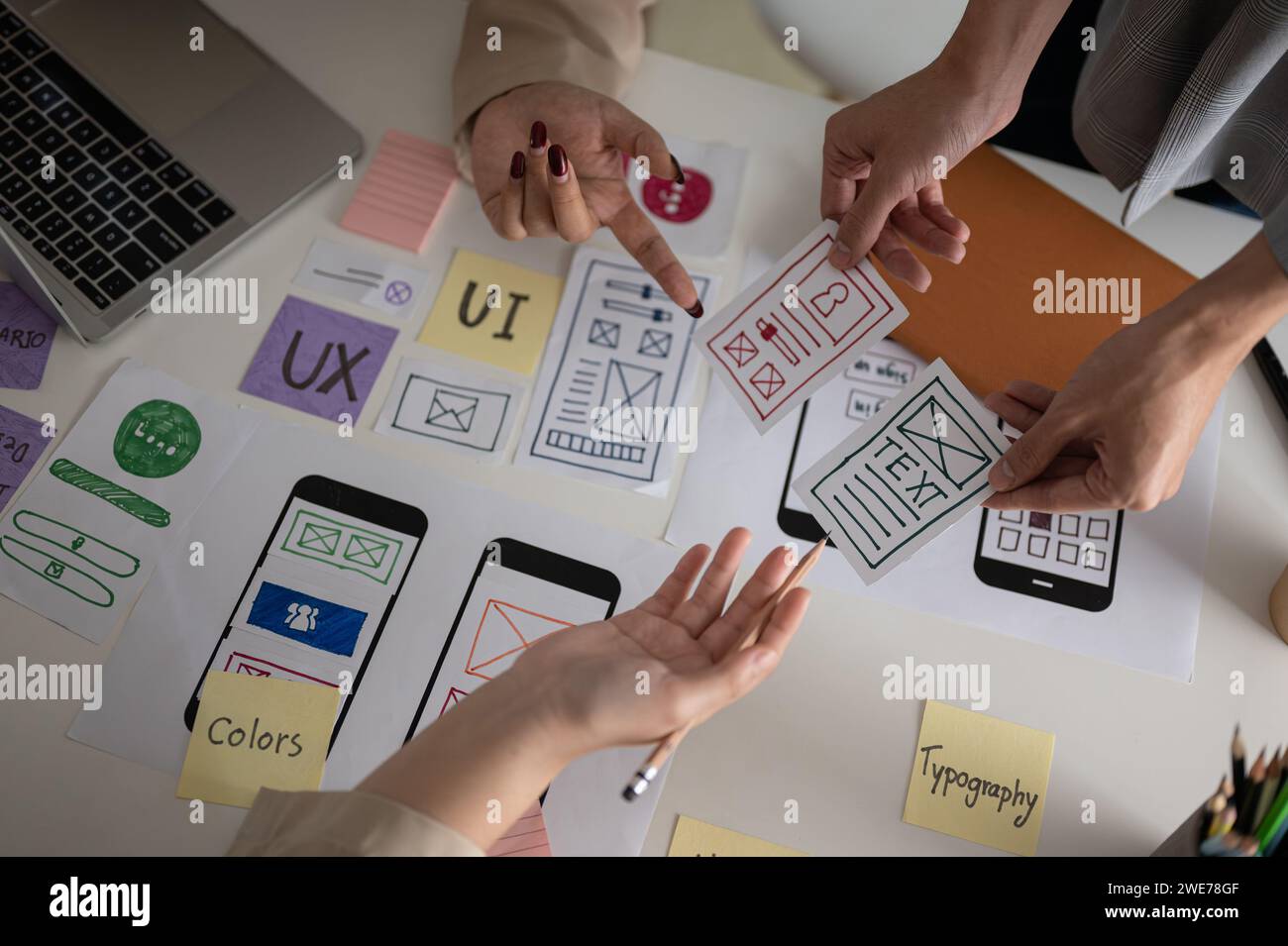 Image vue de dessus d'une équipe de graphistes UX UI professionnelle et créative votant un prototype parfait pour leur nouveau produit, discutant et planifiant WO Banque D'Images
