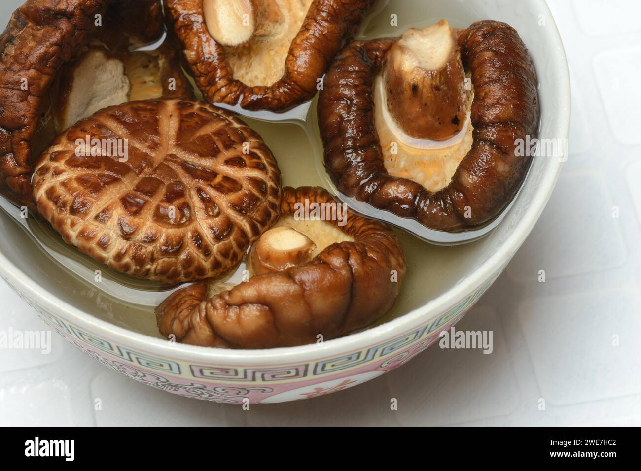 Champignons shiitake séchés dans un bol, trempés dans l'eau Banque D'Images