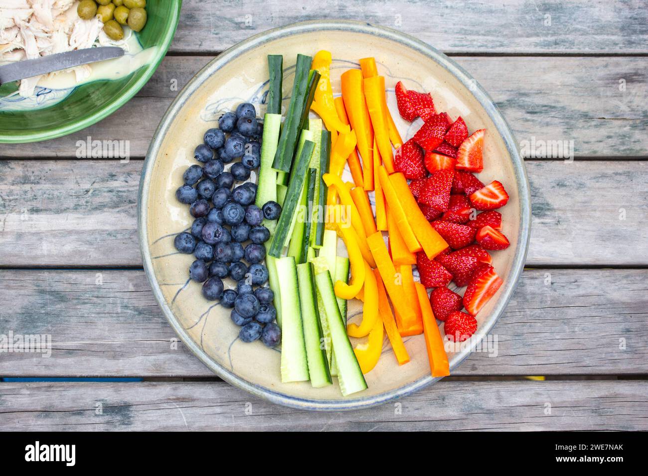 Assiette saine de fruits et légumes sur une table extérieure profitant d'une soirée d'été. Banque D'Images