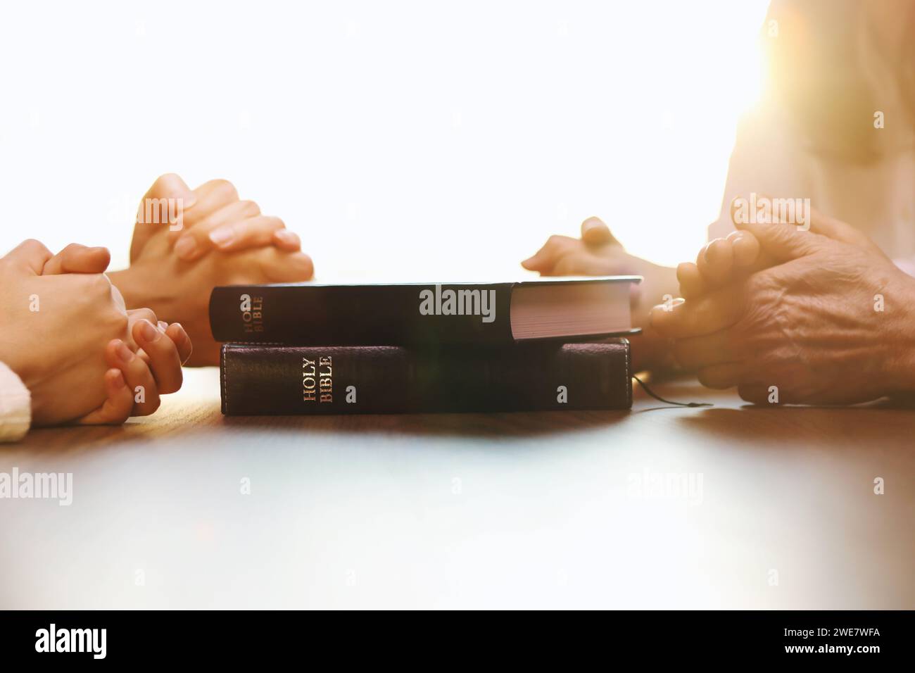 Famille chrétienne se rassemblant à la maison pour prier et adorer, livre biblique, église et religion foi et croyance contexte Banque D'Images