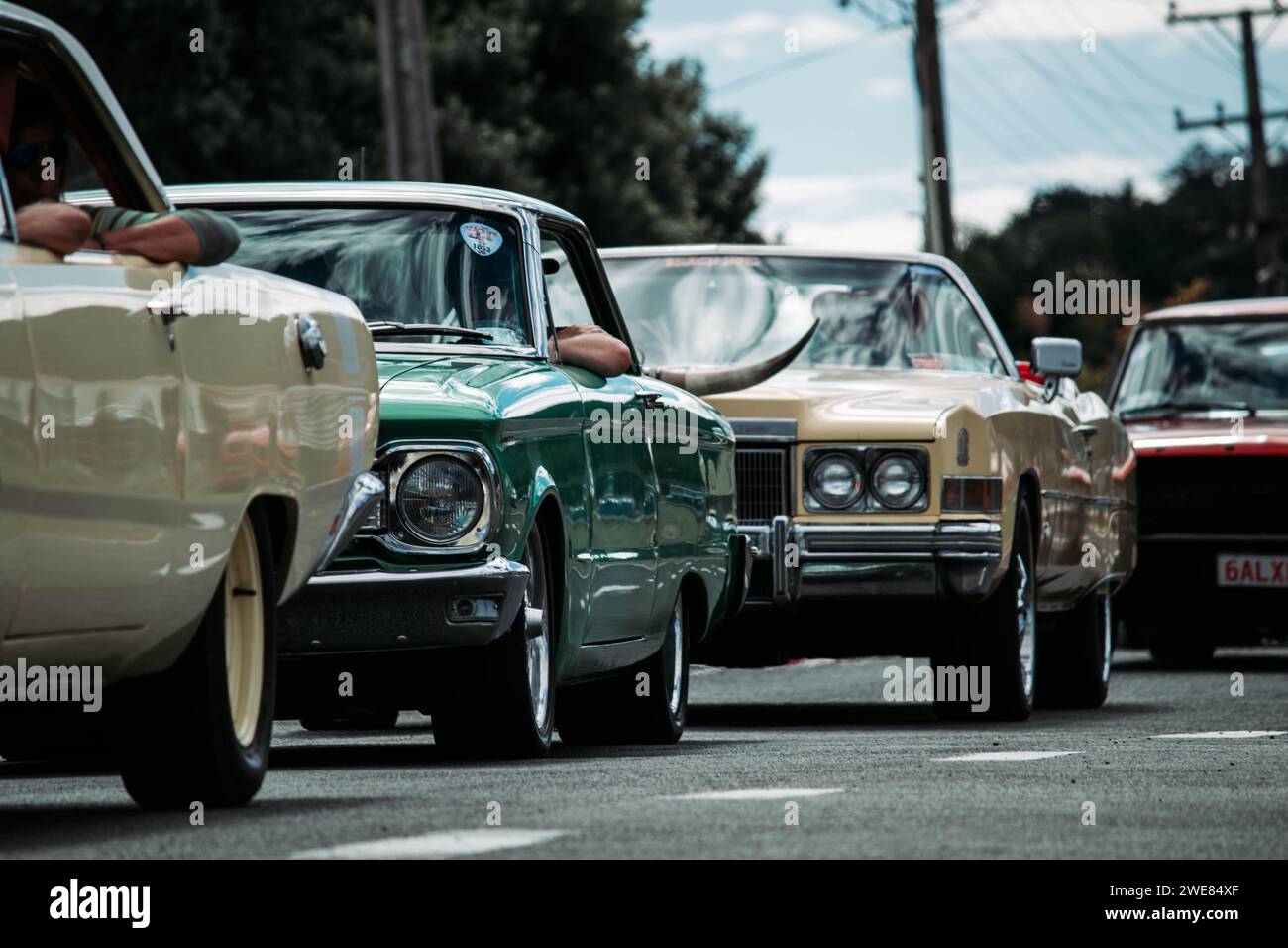 Thames, Nouvelle-Zélande, 25 mars 2021, Whangamata Beach Hop rallye : une ligne de voitures anciennes classiques sur la route. Banque D'Images