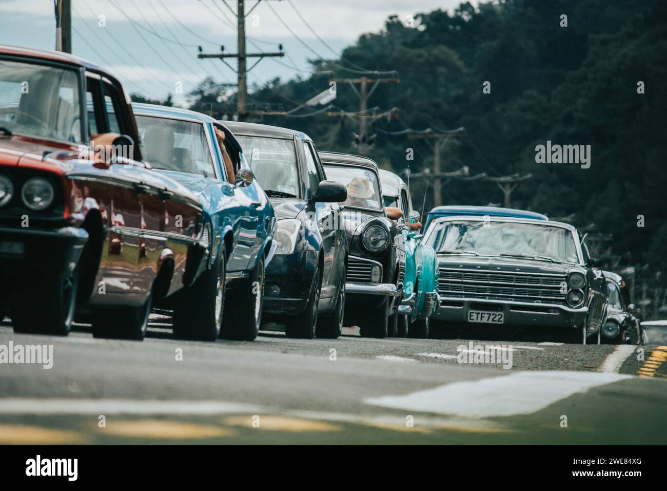 Thames, Nouvelle-Zélande, 25 mars 2021, Whangamata Beach Hop rallye : une ligne de voitures anciennes classiques sur la route. Banque D'Images