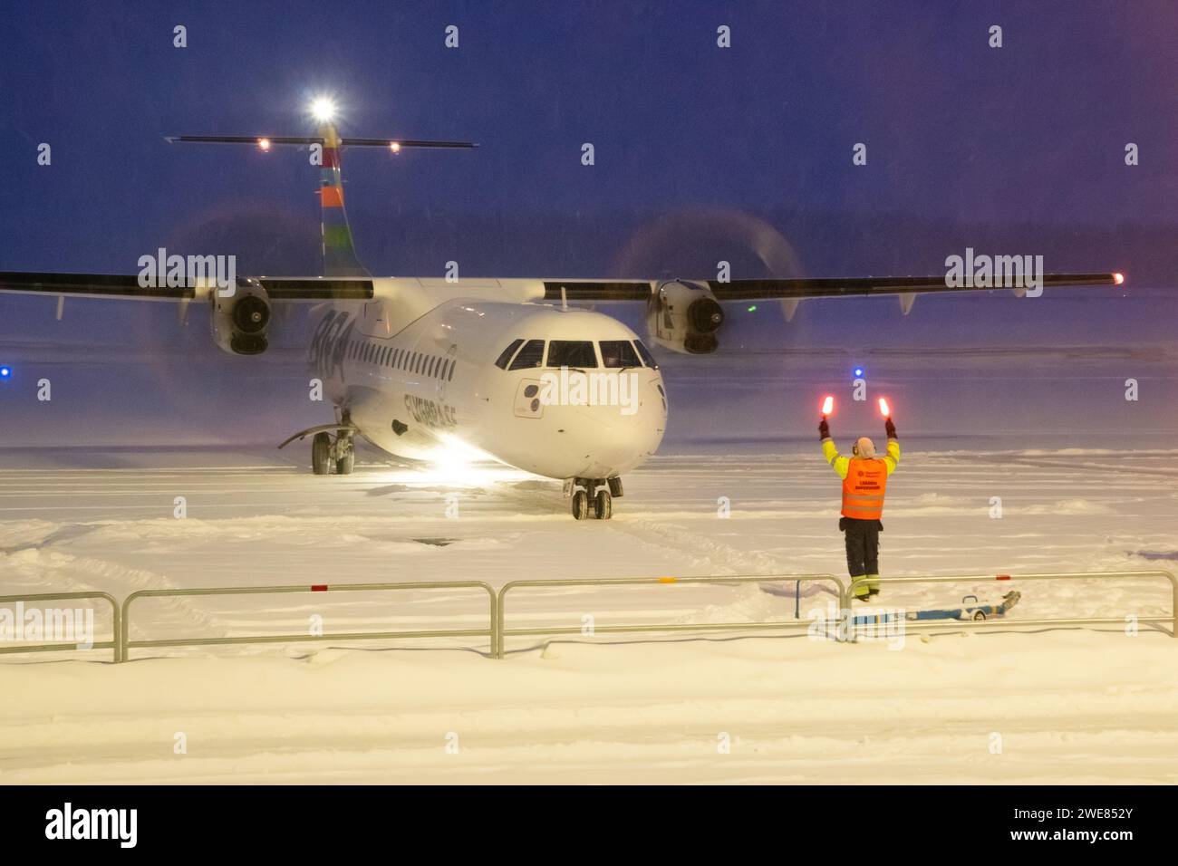 Avion ATR-72-600 de la compagnie aérienne Braathens roulant dans la neige abondante. Avion de passagers dans la neige à l'aéroport. Avion bimoteur de passagers de nuit à Umeå Banque D'Images