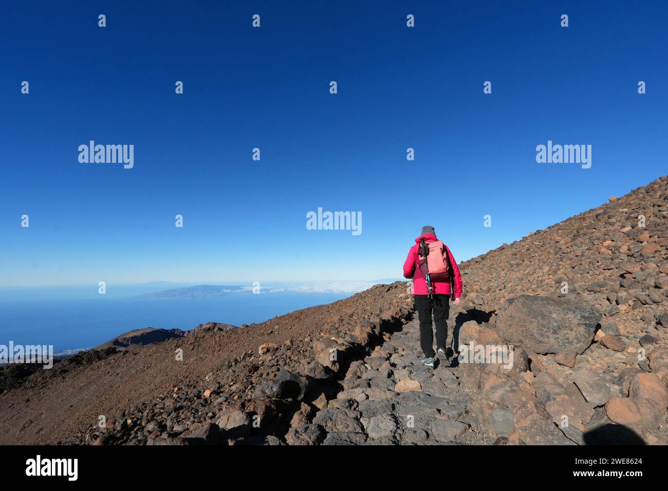 Une personne marche jusqu'à une colline rocheuse sur une journée ensoleillée, sorrounded avec Teide Mountain Banque D'Images