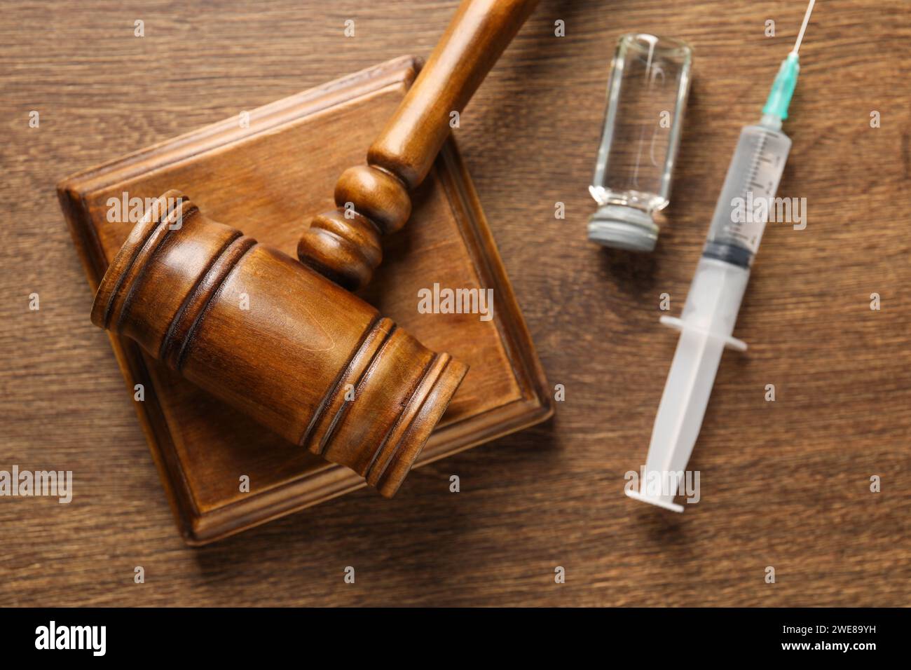 Concept de loi. Marteau, seringue et flacon en verre sur table en bois, vue de dessus Banque D'Images