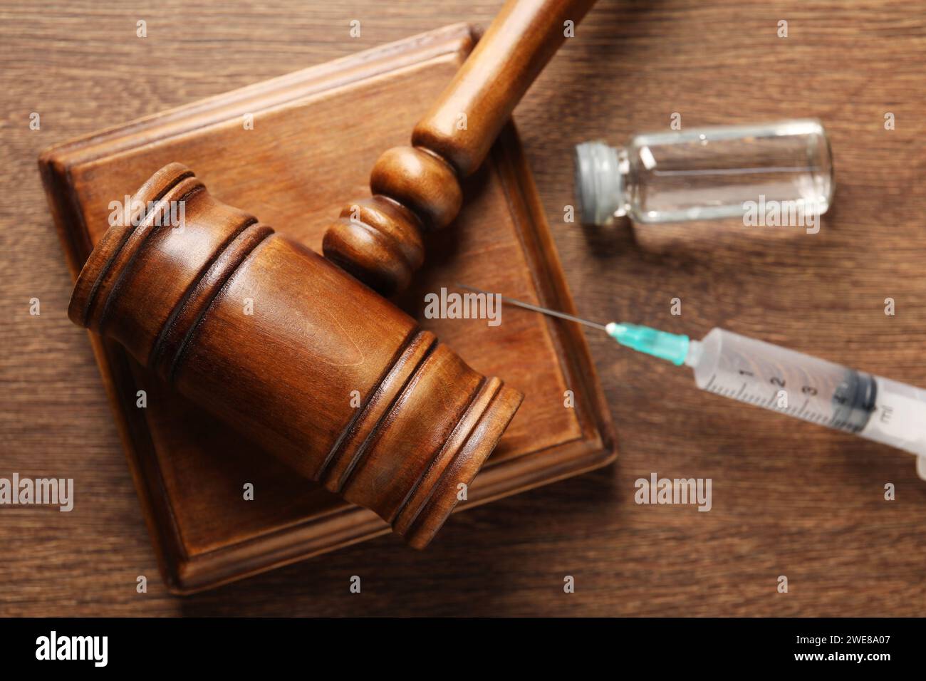 Concept de loi. Marteau, seringue et flacon en verre sur table en bois, vue de dessus Banque D'Images