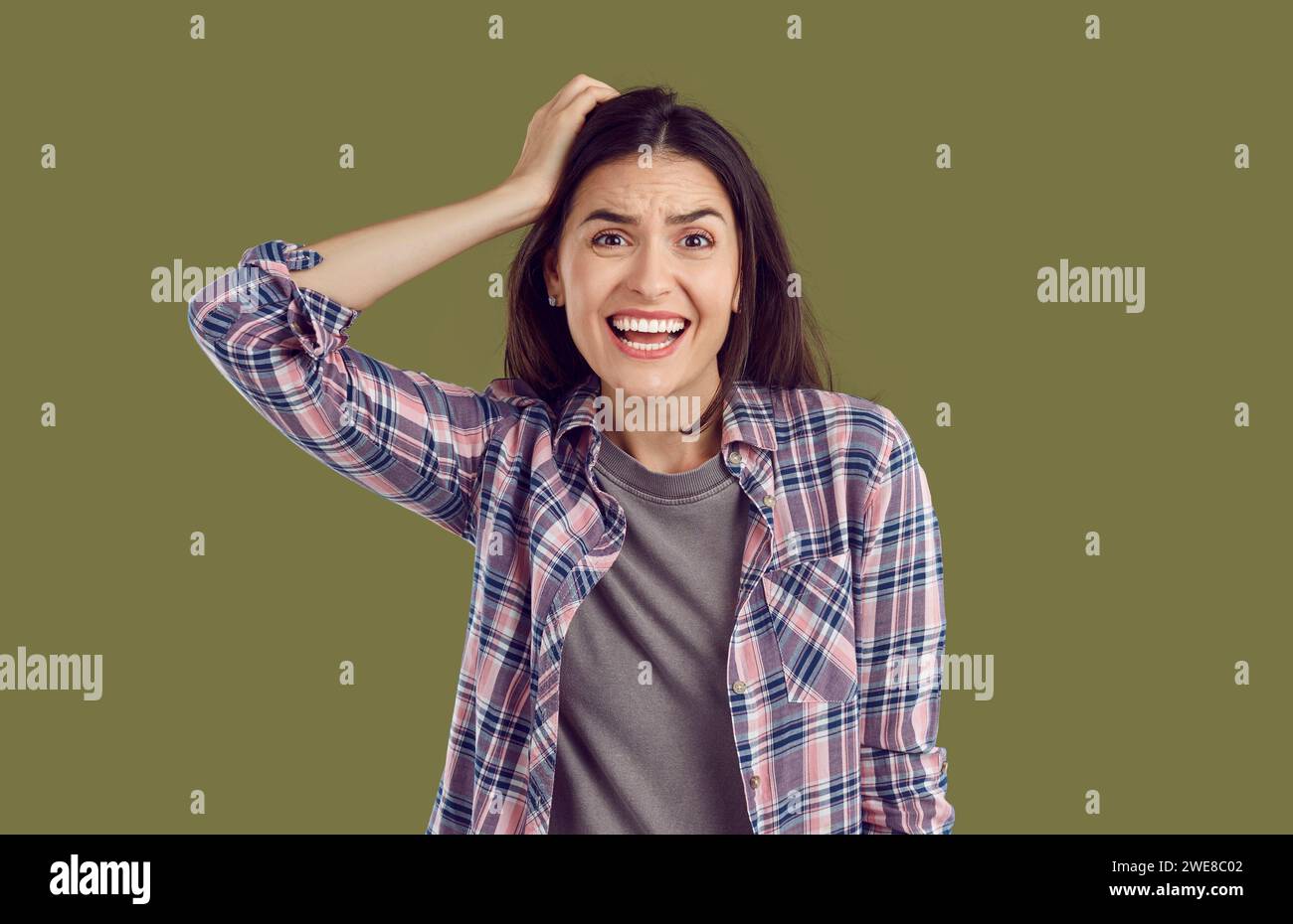Femme stressée et nerveuse tenant la main sur la tête et regardant la caméra avec une expression inquiète Banque D'Images