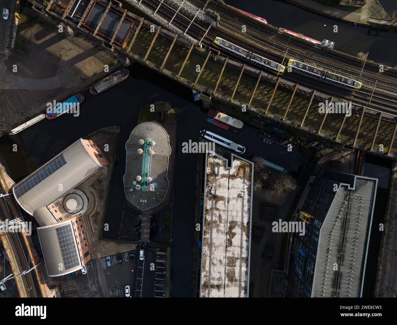 Image de drone regardant vers le bas au viaduc de Castlefield, Giants Basin & Potato Wharf, Manchester, Royaume-Uni, y compris deux tramways et péniches / bateaux de canal amarrés Banque D'Images