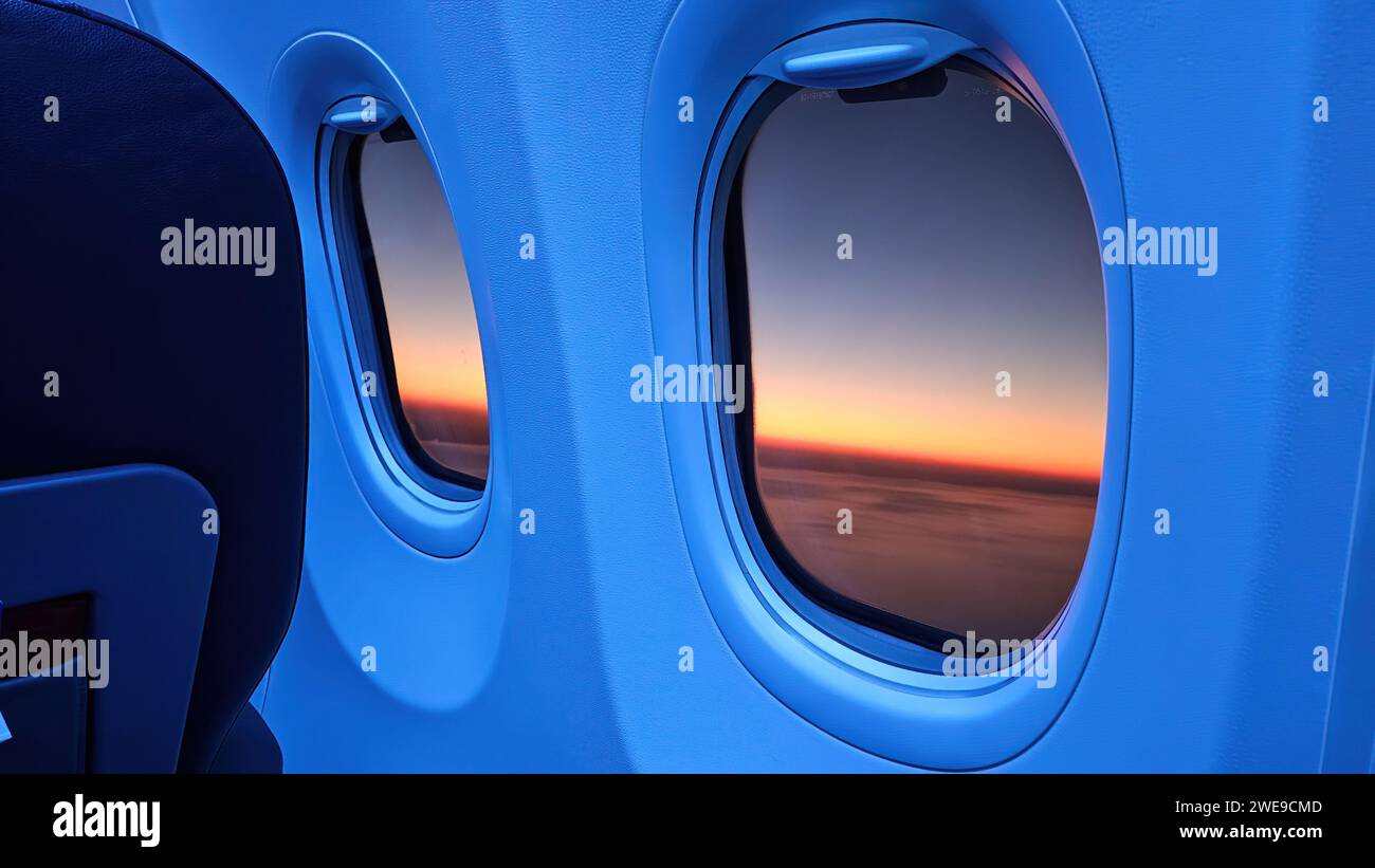 Fenêtre d'avion avec vue coucher de soleil en orange. Banque D'Images