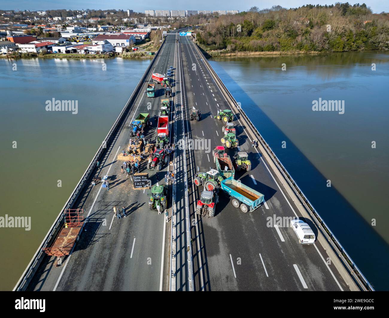 Manifestation de fermiers bloquant l'autoroute A63 (Viaduc Hubert Touya, Bayonne (64100), Pyrénées-Atlantiques (64), Nouvelle Aquitaine, France). Ce mardi 23 janvier 2024, à partir de 6 heures du matin, les agriculteurs des Pyrénées-Atlantiques, à l’appel de la FDSEA 64 et des jeunes agriculteurs, ont organisé des points de blocage aux échangeurs de Bayonne. La circulation est interrompue ce mardi sur cette portion de l’autoroute par des manifestants déterminés. Les manifestations agricoles sont un signe de la crise à laquelle est confronté le secteur agricole en France et en Europe. Banque D'Images