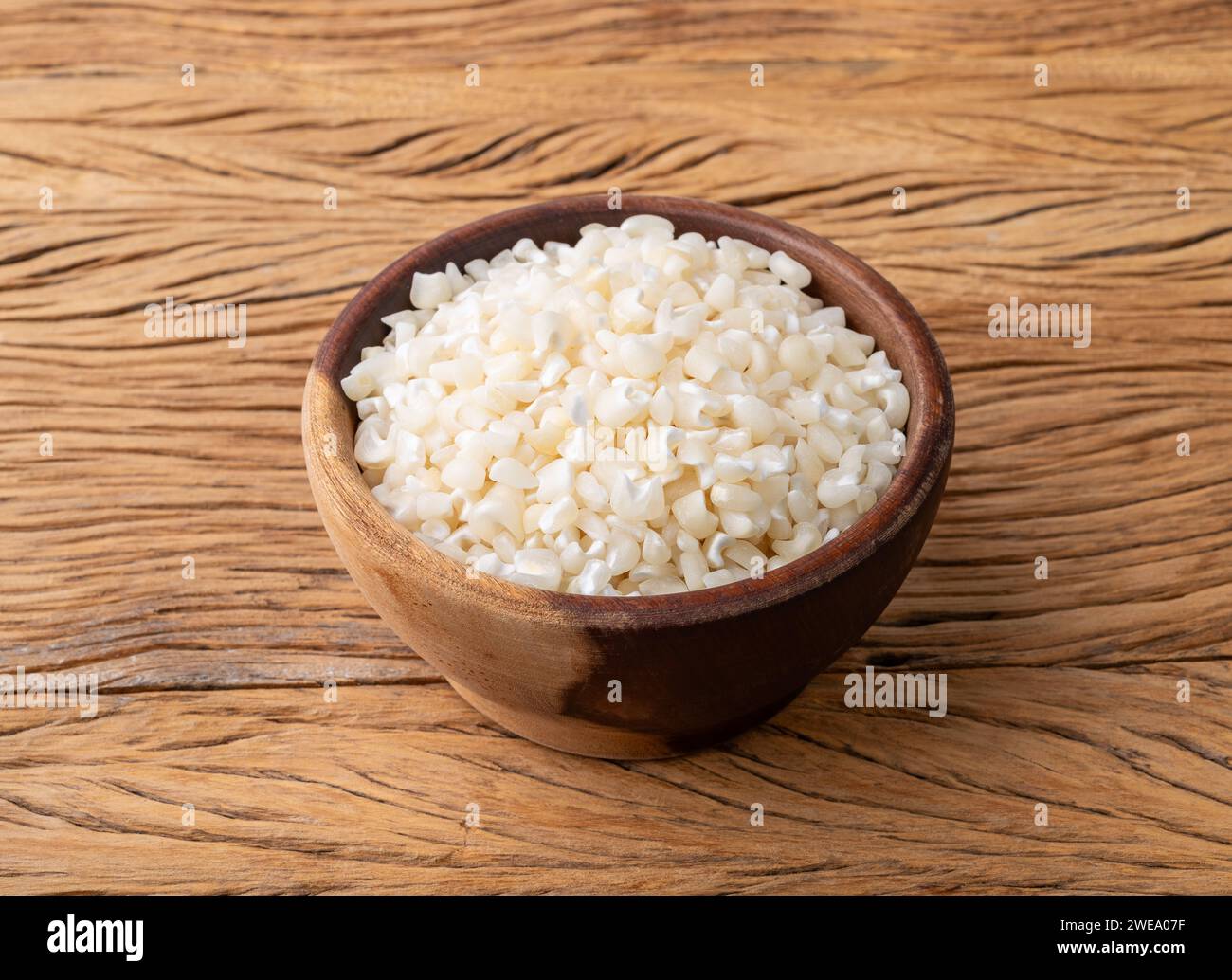 Canjica séché, maïs hominy ou blanc sur un bol sur une table en bois. Banque D'Images