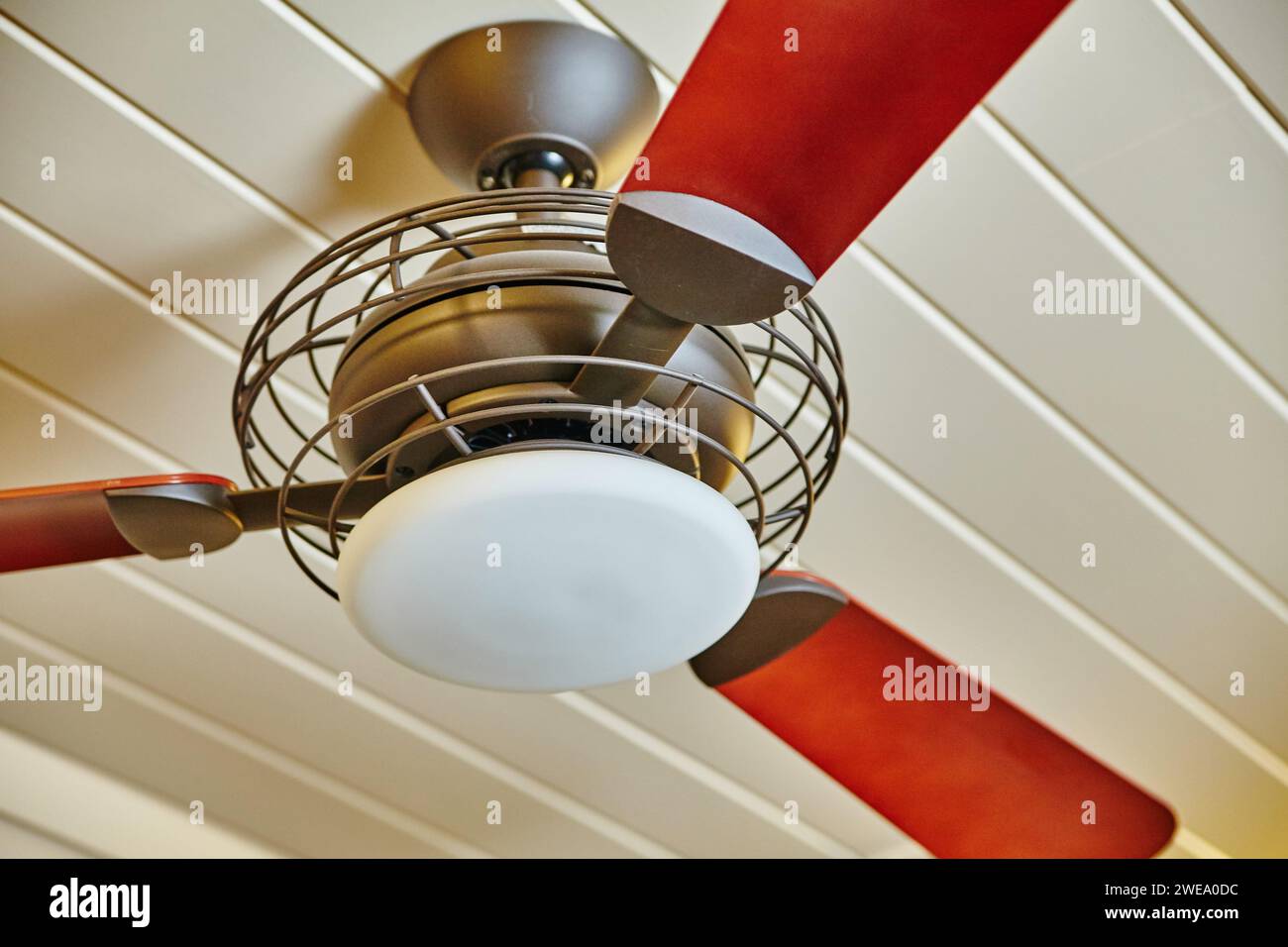 Ventilateur de plafond rouge et acajou moderne avec lumière, vue vers le haut Banque D'Images