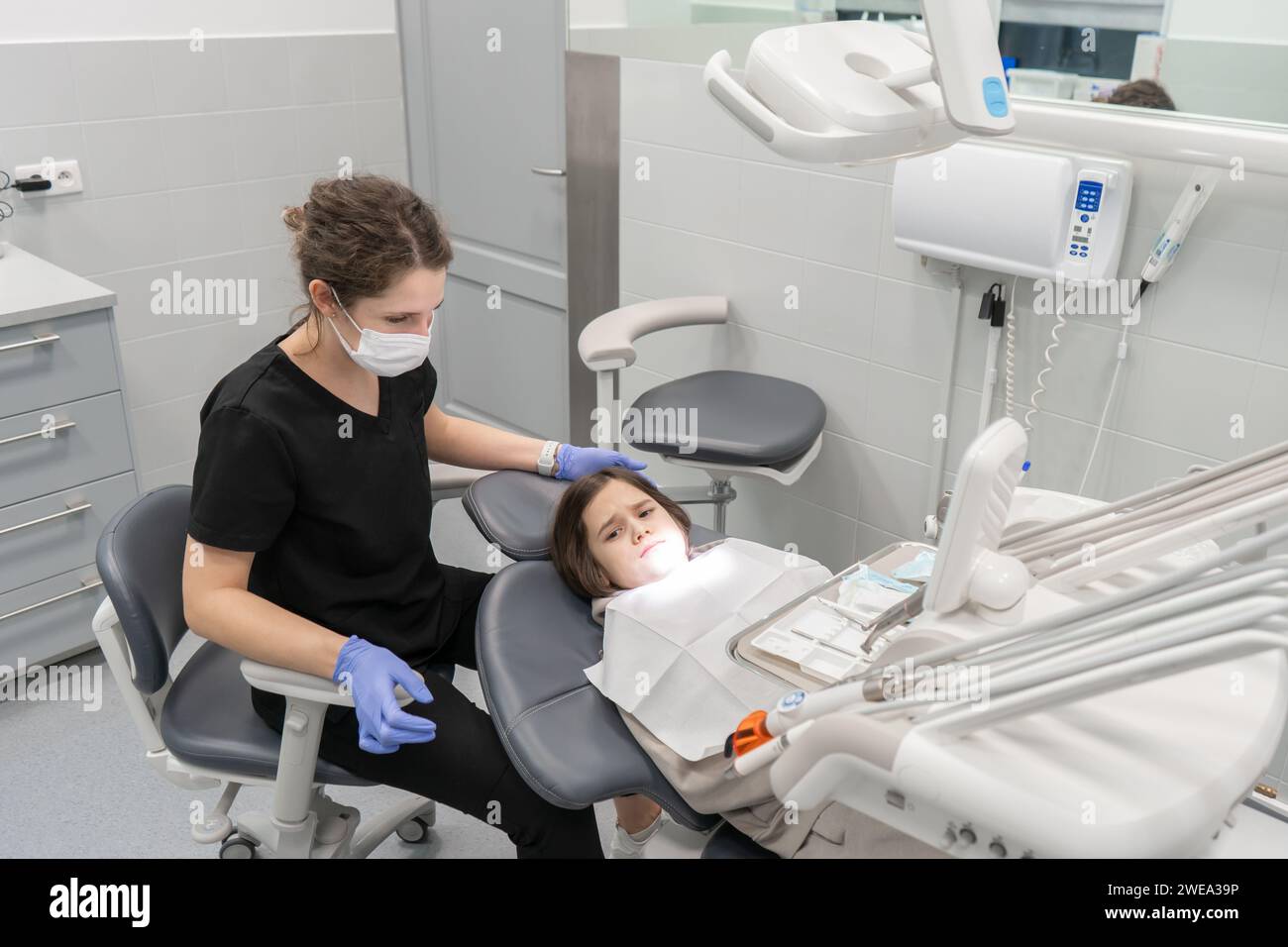 Un dentiste pédiatrique examine un enfant anxieux qui vient à un rendez-vous pour la première fois. Examen médical d'un enfant chez un dentiste pédiatrique Banque D'Images