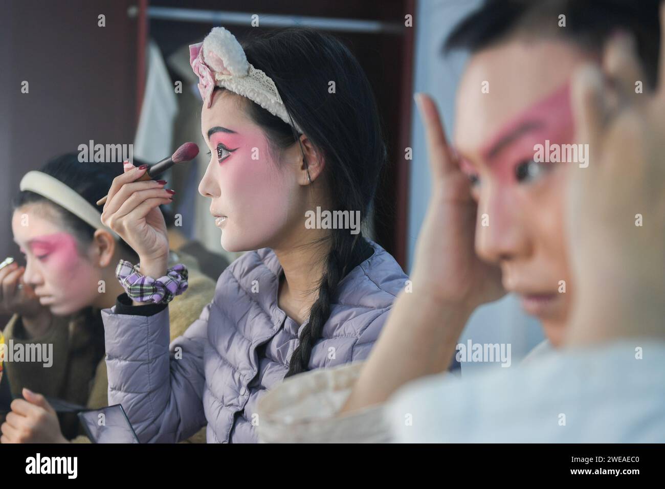 WUHAN, 24 janvier 2024 (Xinhua) -- une actrice (C) de l'Opéra de Hanju se maquille à Wuhan, dans la province du Hubei en Chine centrale, le 23 janvier 2024. Depuis 2016, afin de réserver des talents aux opéras, le Hubei Drama Art Theatre a sélectionné et recruté plus de 150 étudiants de l'Opéra de Chuju, de l'Opéra de Hanju et de l'Opéra de Huangmei, et a confié à Hubei College of the Arts une formation directionnelle. Après sept ans d'étude de l'opéra et un an de stage, ce groupe de jeunes acteurs d'opéra est monté sur la scène du gala de remise des diplômes avec leurs meilleures performances. (Xinhua/du Zixuan) Banque D'Images