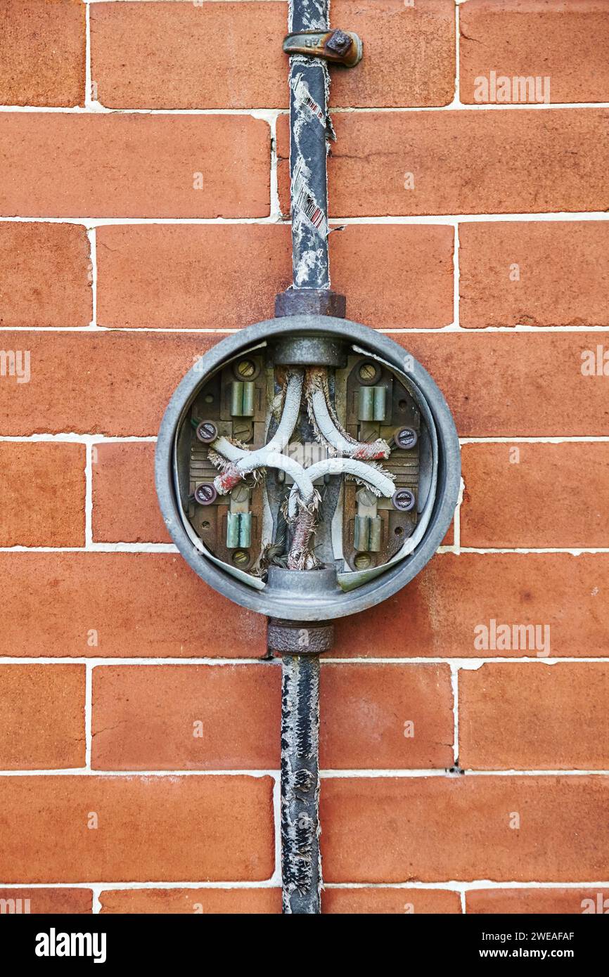 Boîtier de raccordement électrique vieilli sur le mur de briques, vue au niveau des yeux Banque D'Images