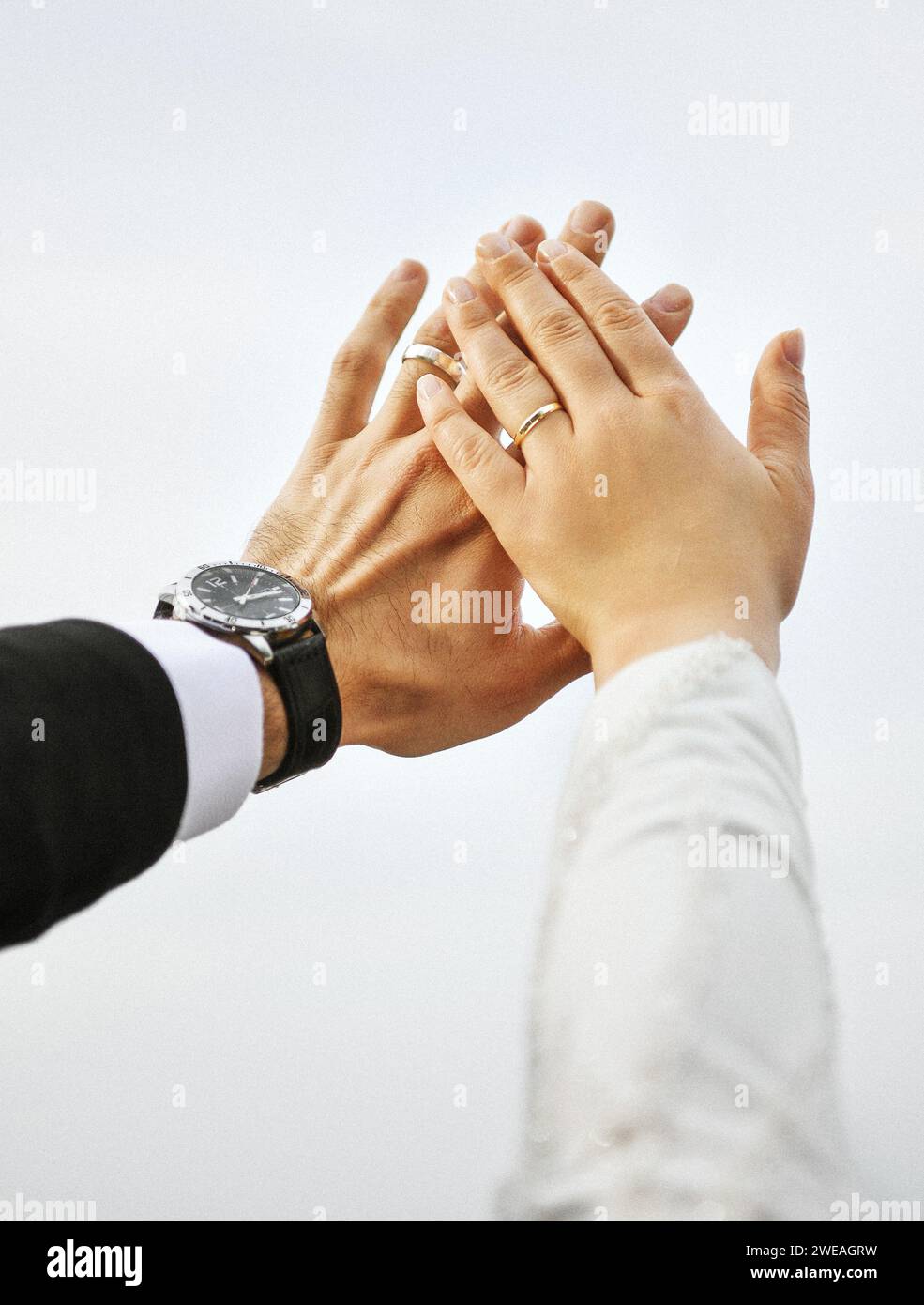 Gros plan de la main de la mariée et du marié portant une bague Banque D'Images