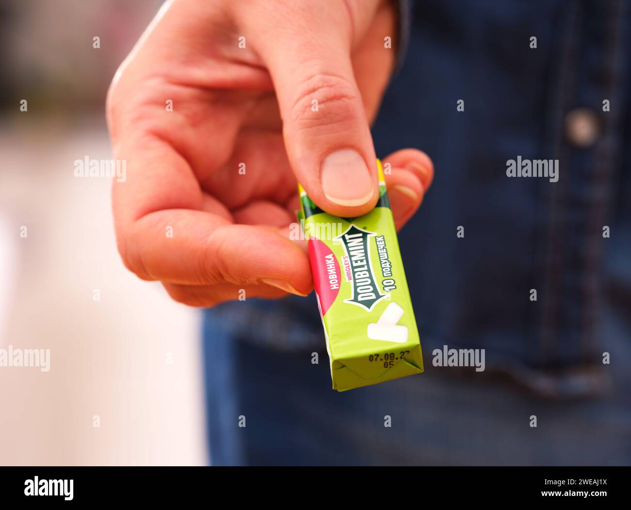 Tambov, Fédération de Russie - 20 décembre 2023 Une femme donne un paquet de chewing-gum Doublemint de Wrigley. Banque D'Images