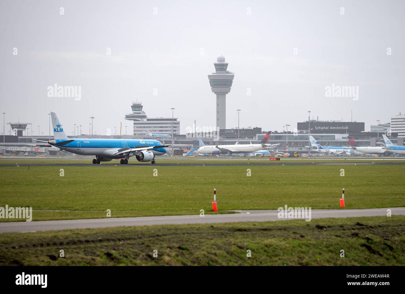 Amsterdam pays-Bas 24 janvier 2024 atterrissage d'avions à l'aéroport de Schiphol. KLM Embraer E195-E2 pH-NXC avec les terminaux, la tour de contrôle et les jetées au loin. néerlandais, nl, vliegtuig, flugzeug, aankomst, arrivée, avion, buitenveldertbaan, Banque D'Images