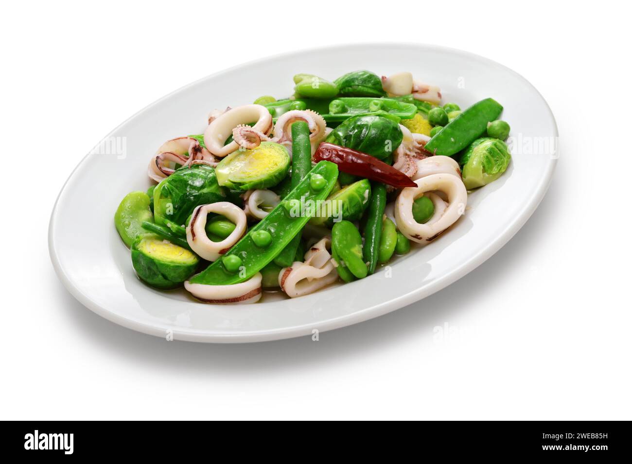 Salade printanière avec petits pois, haricots, choux de bruxelles et calamars. Banque D'Images