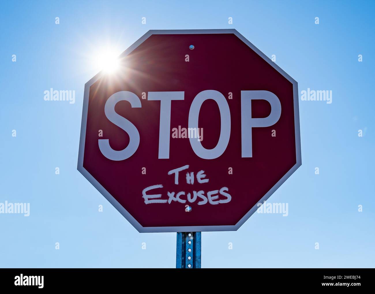 Photo d'un panneau d'arrêt rouge avec le soleil brillant sur le bord disant arrêter les excuses Banque D'Images