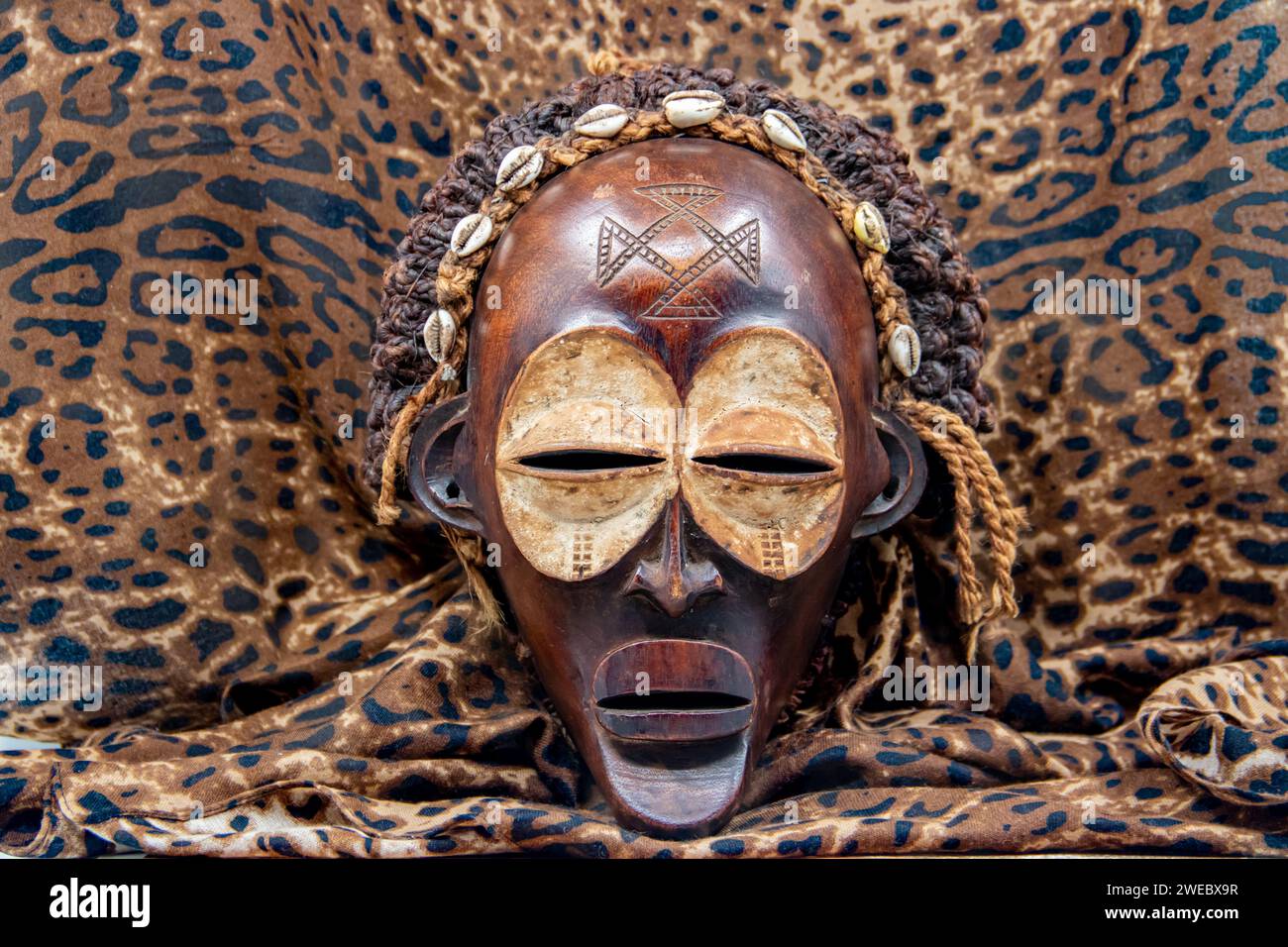 Masque africain tribal en bois de l'Ouganda, pour la protection de la famille ou personnelle, fait de bois local, cordes et coquillages comme décoration de cheveux Banque D'Images