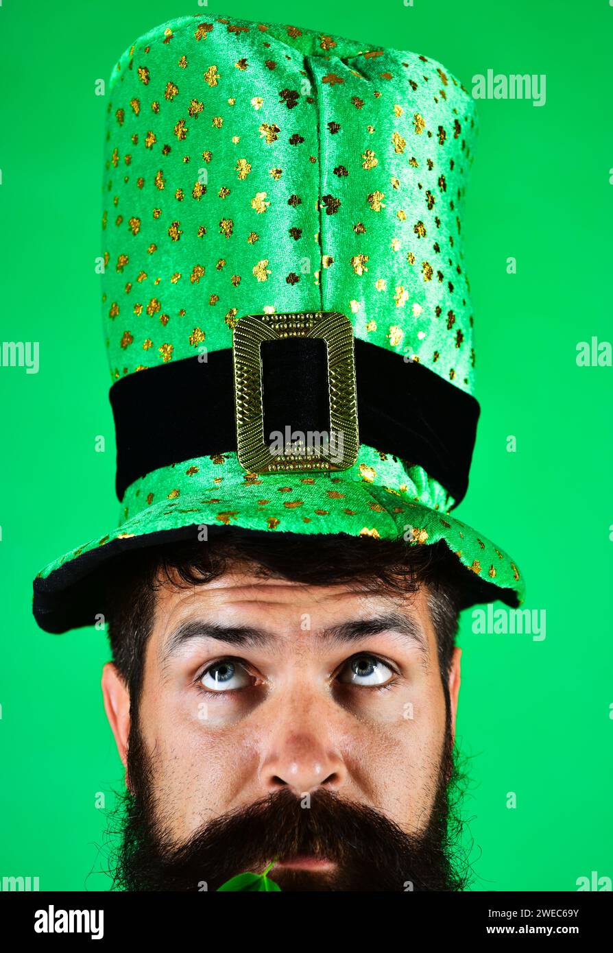 Fête de la Saint Patrick. Homme pensif en haut-de-forme vert à la fête de Patrick. Gros plan portrait gars barbu sérieux dans le chapeau de leprechaun vert avec Banque D'Images