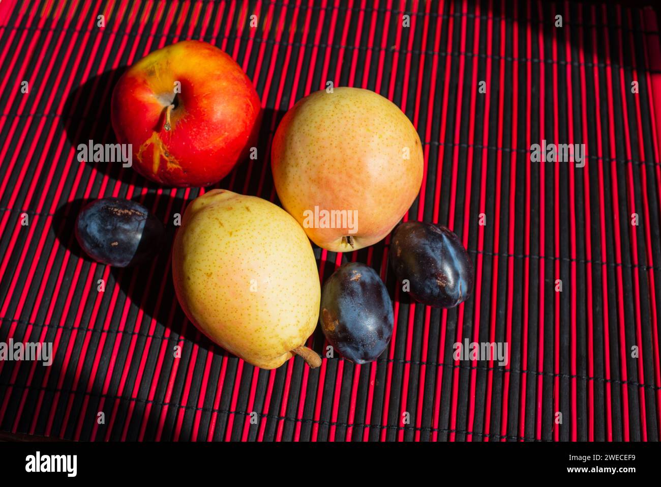 Il y a des pommes, des poires et des prunes sur la table. Fruits frais en gros plan. Banque D'Images
