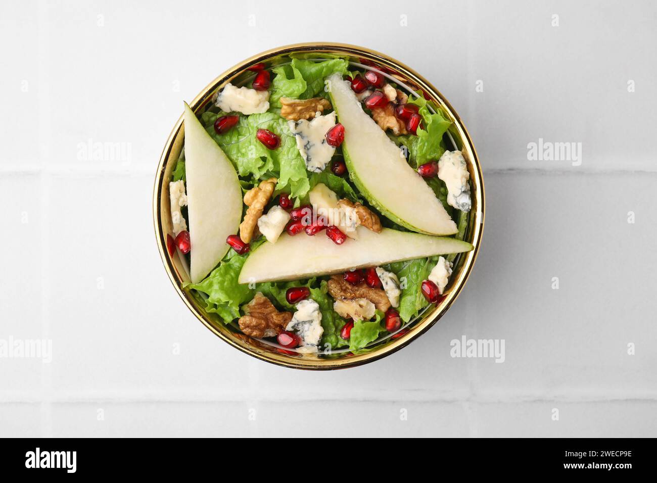 Délicieuse salade de poires dans un bol sur une table carrelée légère, vue de dessus Banque D'Images