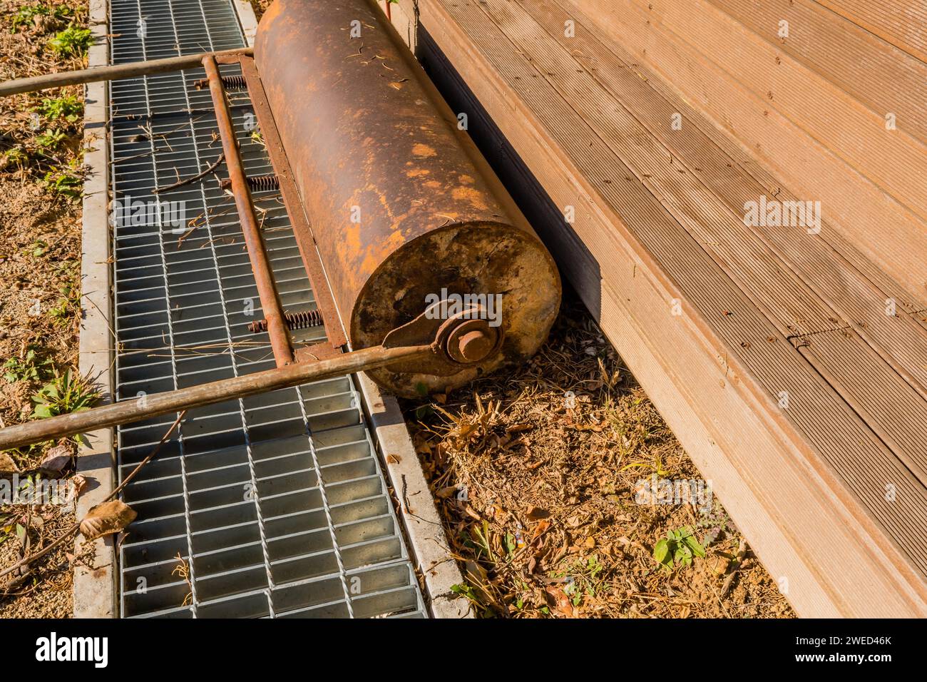 Rouleau de surface poussé à la main devant des bancs de stade en bois au bord du champ de terre Banque D'Images