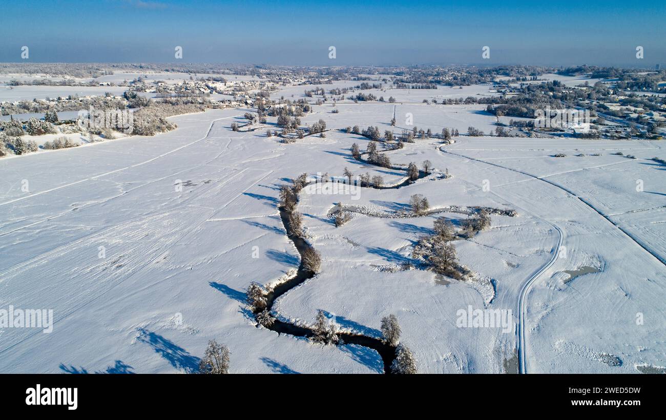 Drone shot de la rivière Schmutter serpentant naturellement à travers le paysage hivernal enneigé du parc naturel Western Forests près d'Augsbourg Banque D'Images