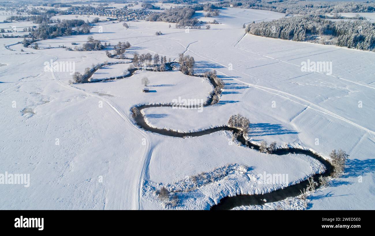 Drone shot de la rivière Schmutter serpentant naturellement à travers le paysage hivernal enneigé du parc naturel Western Forests près d'Augsbourg Banque D'Images