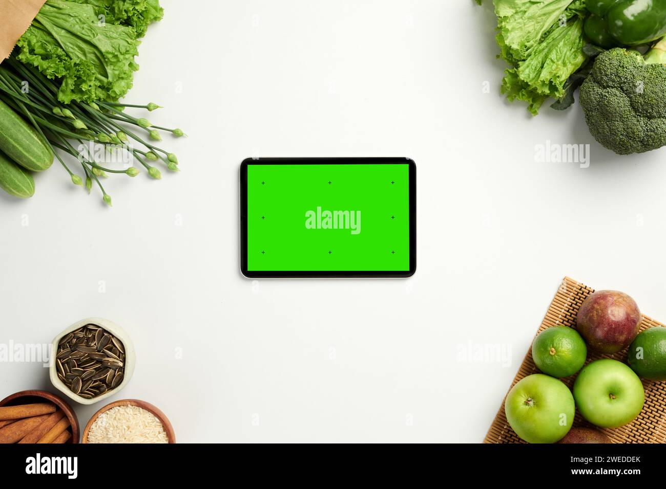Tablette avec écran vert sur tablette avec divers fruits et légumes Banque D'Images