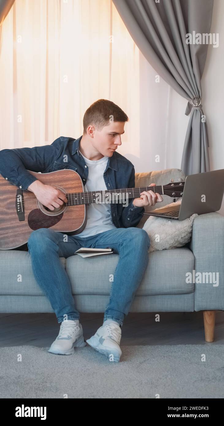 Pratique de la guitare cours en ligne homme ordinateur portable maison Banque D'Images