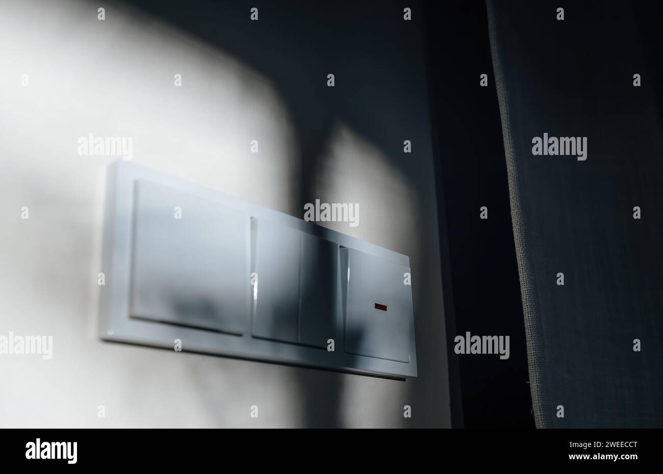 Une image visuellement agréable montre plusieurs interrupteurs d'éclairage de conception allemande montés sur un mur, magnifiquement éclairés par la lumière du soleil Banque D'Images