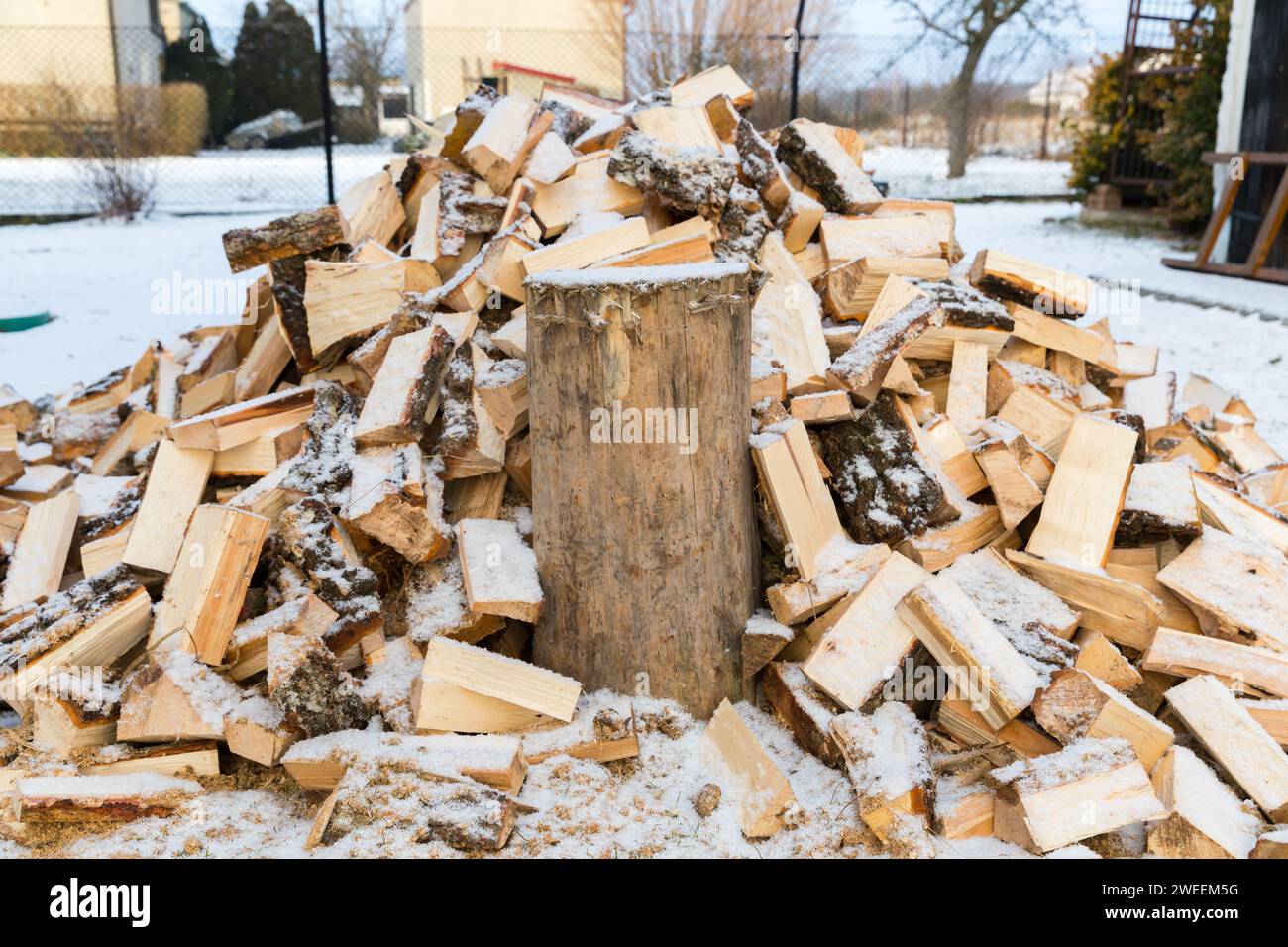 Une hache pour fendre le bois de chauffage collée dans une souche pour couper le bois. Banque D'Images