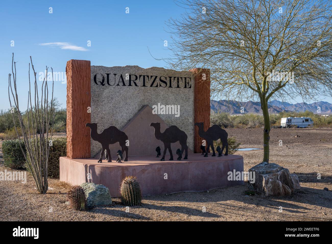 Le panneau aux limites de la ville de Quartzsite, Arizona, avec les montagnes Dome Rock derrière. Banque D'Images