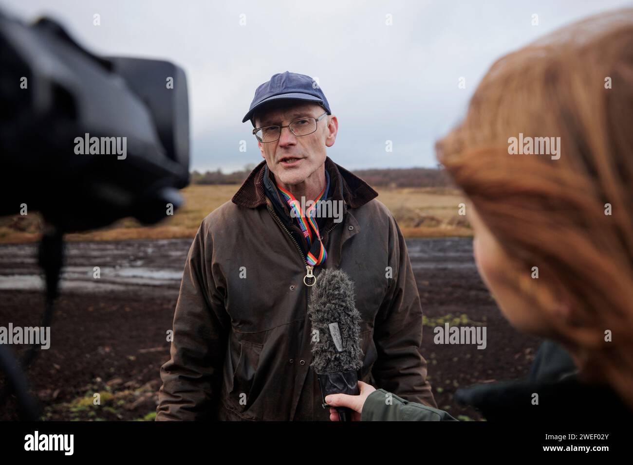 Le Dr Alastair Ruffell de Queens University Belfast s'adressant aux médias près du site de Bellaghy, Co Londonderry, où des restes humains de carbone datés de 2 000 à 2 500 ans ont été trouvés. Un anthropologue médico-légal certifié a déterminé que les restes antiques sont probablement un homme âgé entre 13-17 ans au moment de la mort. L'unité archéologique de l'équipe de récupération du corps du PSNI a fait la découverte lors de fouilles, après avoir été alertée de la présence d'os humains à la surface de tourbières à Bellaghy en octobre 2023. Date de la photo : jeudi 25 janvier 2024. Banque D'Images