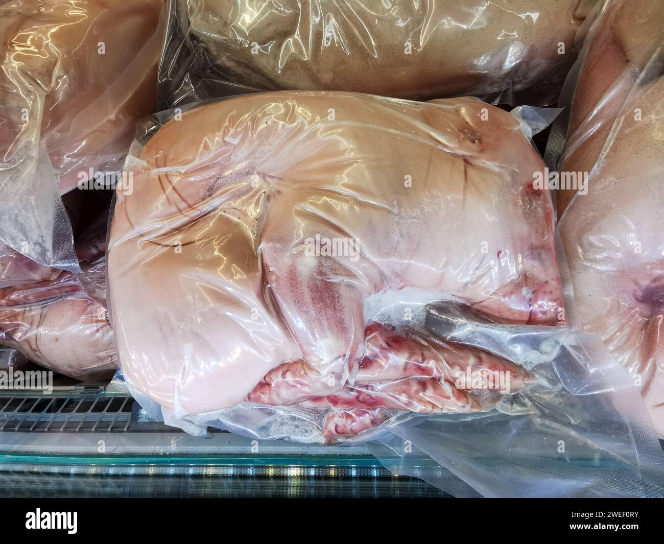 Carcasse d'un petit cochon de lait dans un emballage sous vide, congelée au congélateur. Banque D'Images