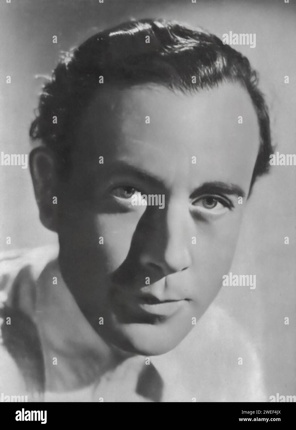 Portrait de Dennis Price, acteur connu pour son rôle dans le film Hungry Hill (1947). Dans ce drame britannique, adapté du roman de Daphne du Maurier, Price joue John Brodrick, un membre d'une famille impliquée dans une longue querelle sur une mine de cuivre en Irlande. Le film s'étend sur plusieurs générations, avec le personnage de Price au centre du conflit. Banque D'Images