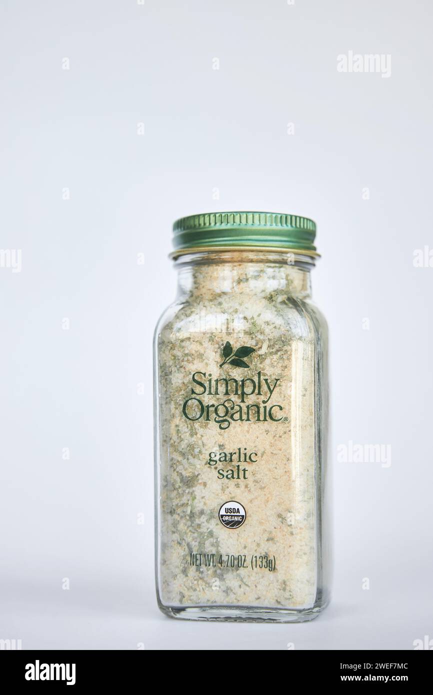 Marque Simply Organic. Pot en verre de sel d'ail, épices d'assaisonnement sur fond gris. Récipient avec couvercle en aluminium vert, emballage recyclable. IHerb activé Banque D'Images