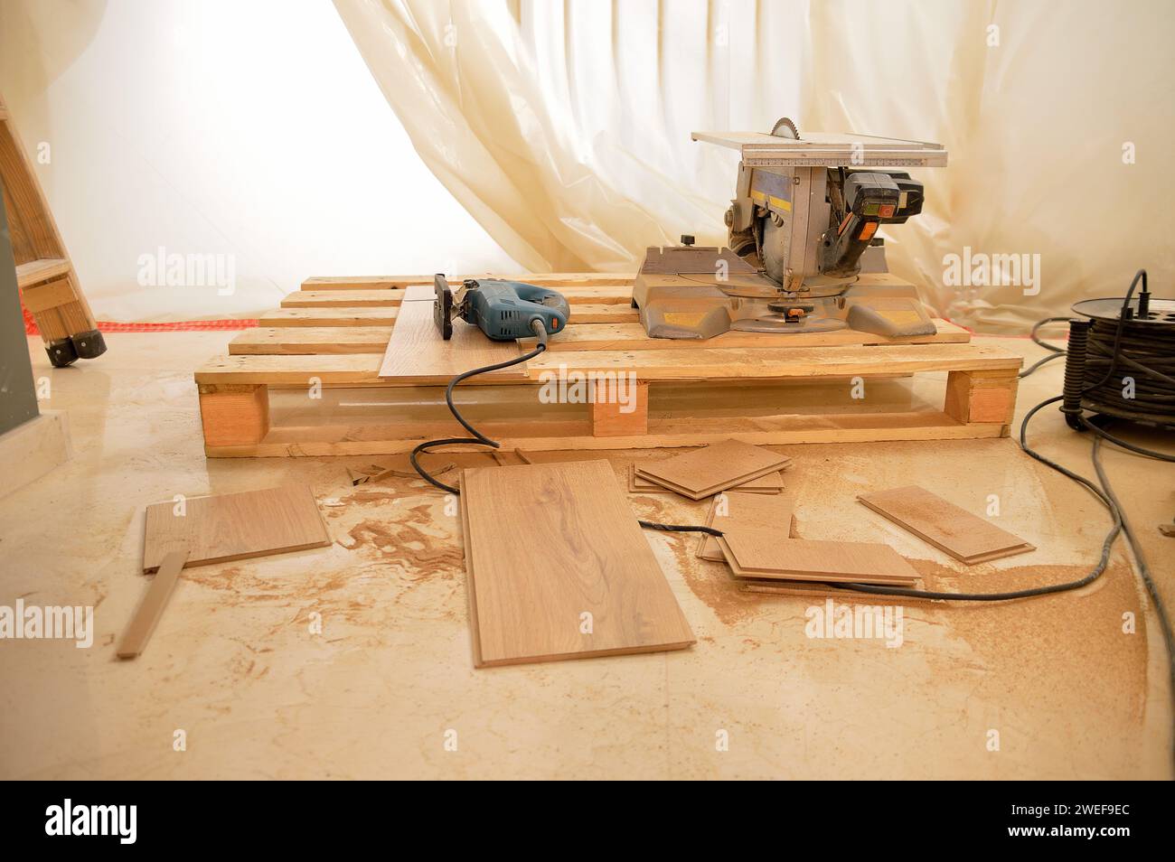outils de coupe pour l'installation de bois stratifié dans une maison avec protection plastique Banque D'Images