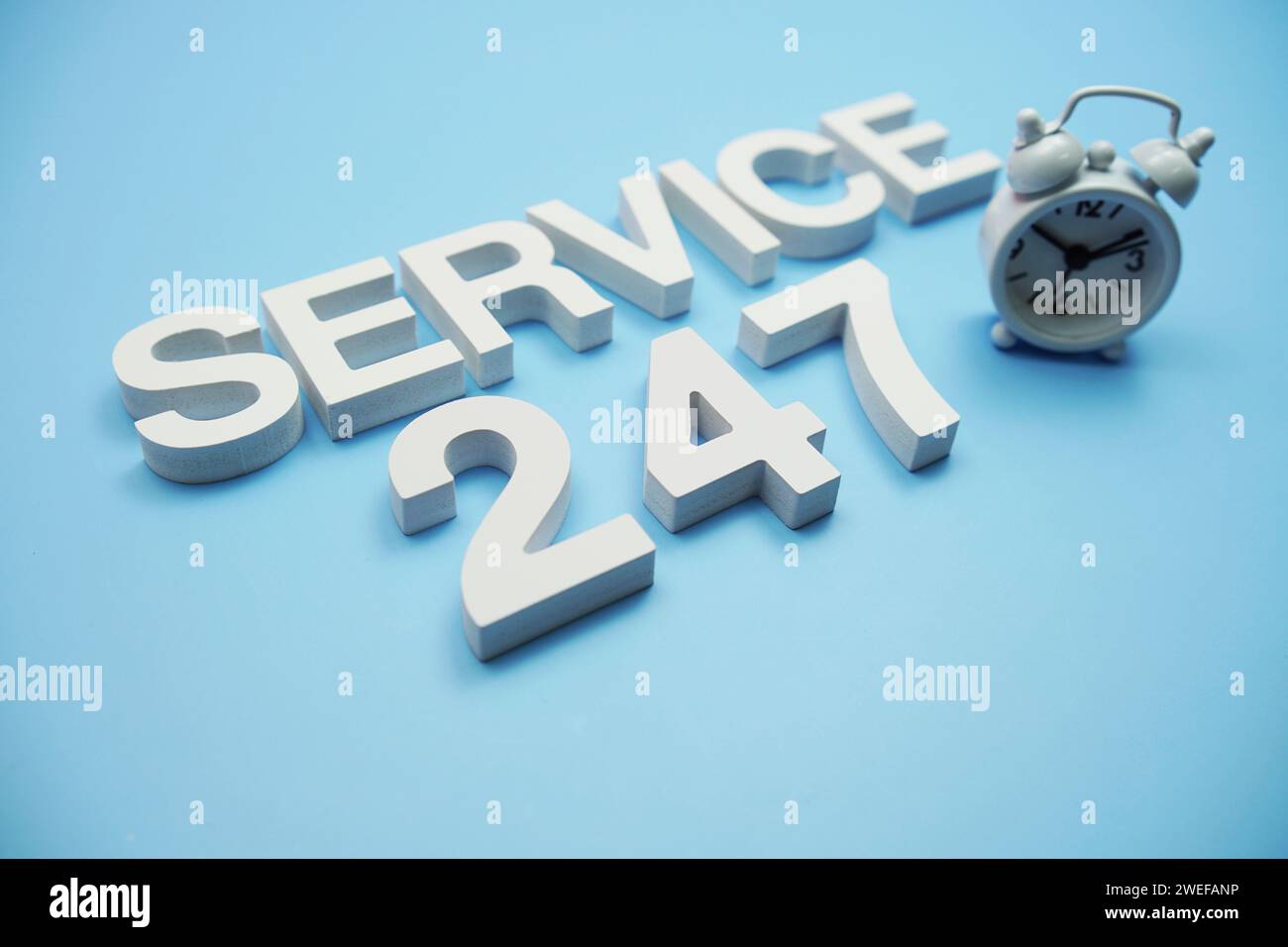 24/7 lettres de l'alphabet de service sur fond bleu Banque D'Images
