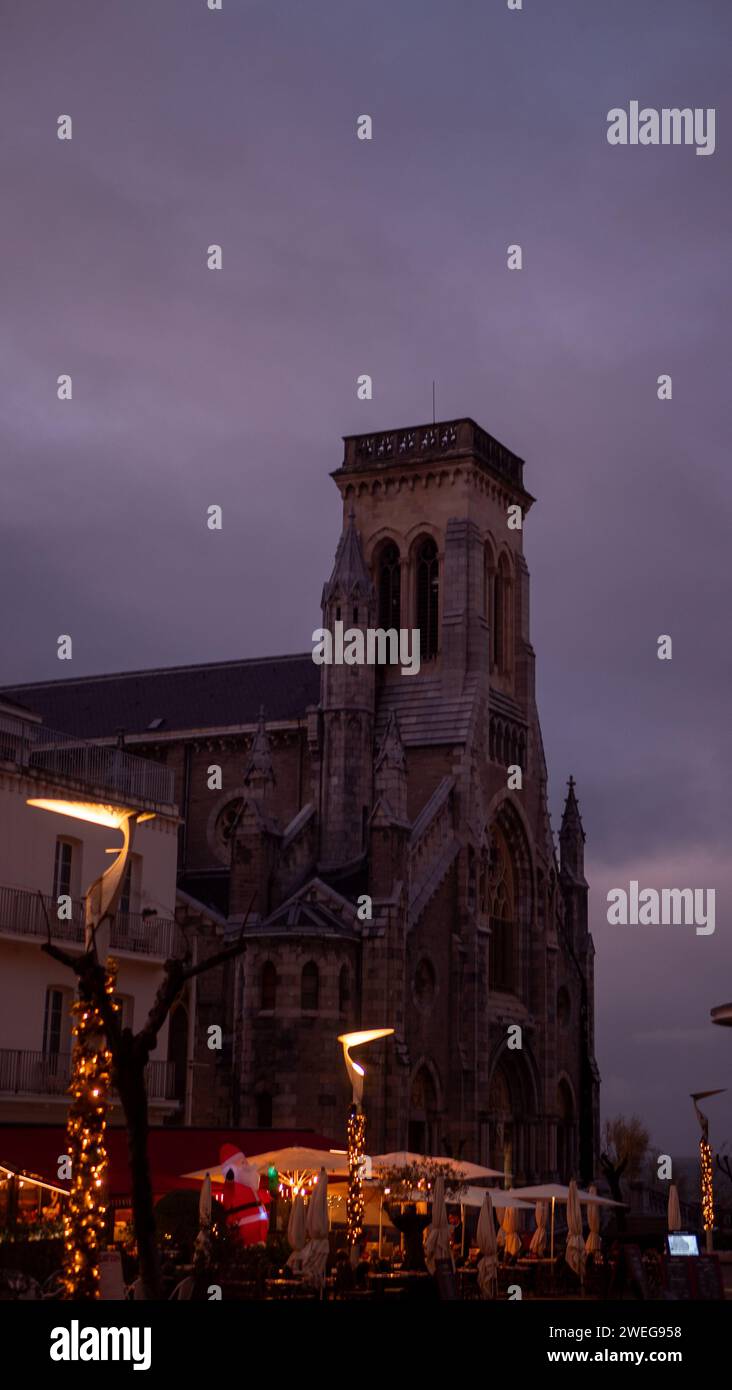 Place de la ville avec des arbres de Noël autour d'une grande tour, les gens assis à des tables Banque D'Images