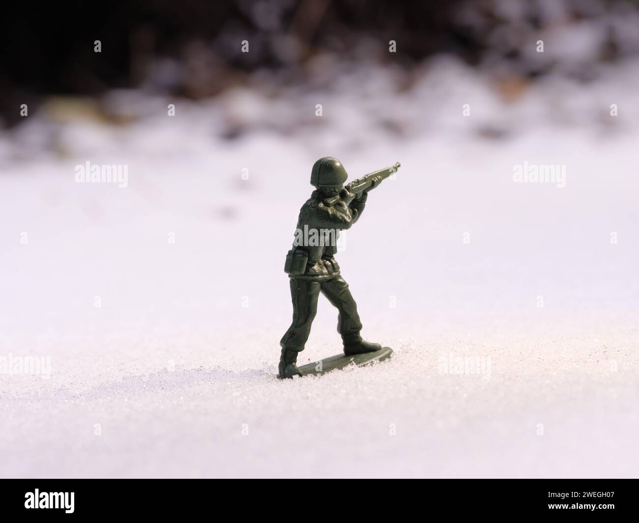 Soldat jouet de guerre en plein jour sur un paysage de champ de bataille froid et enneigé. Banque D'Images