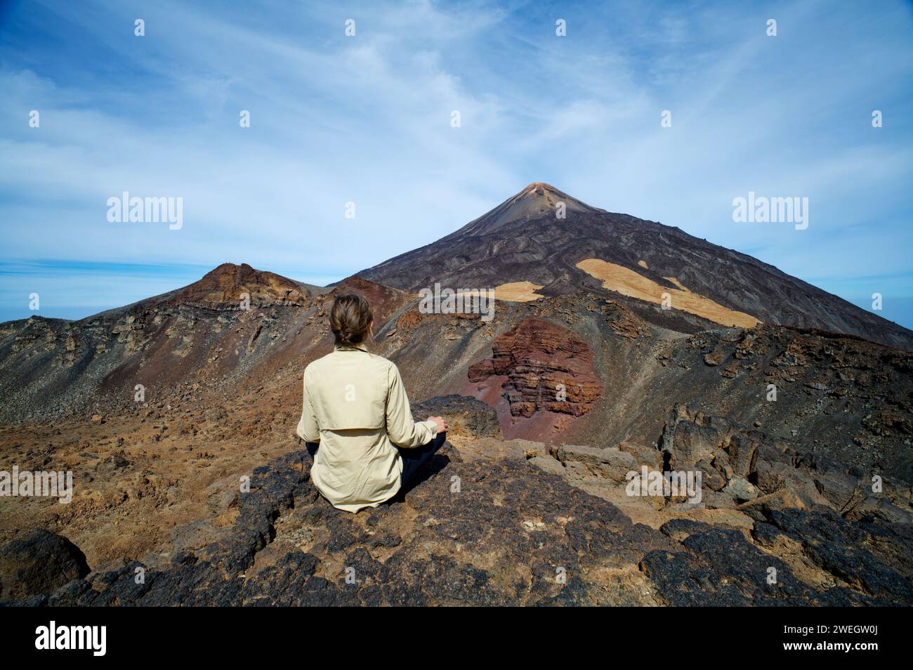 Une personne féminine assise à la montagne Pico Viejo regardant vers le mont Teide à Tenerife, îles Canaries, Espagne. Destinations célèbres pour les randonneurs. Banque D'Images